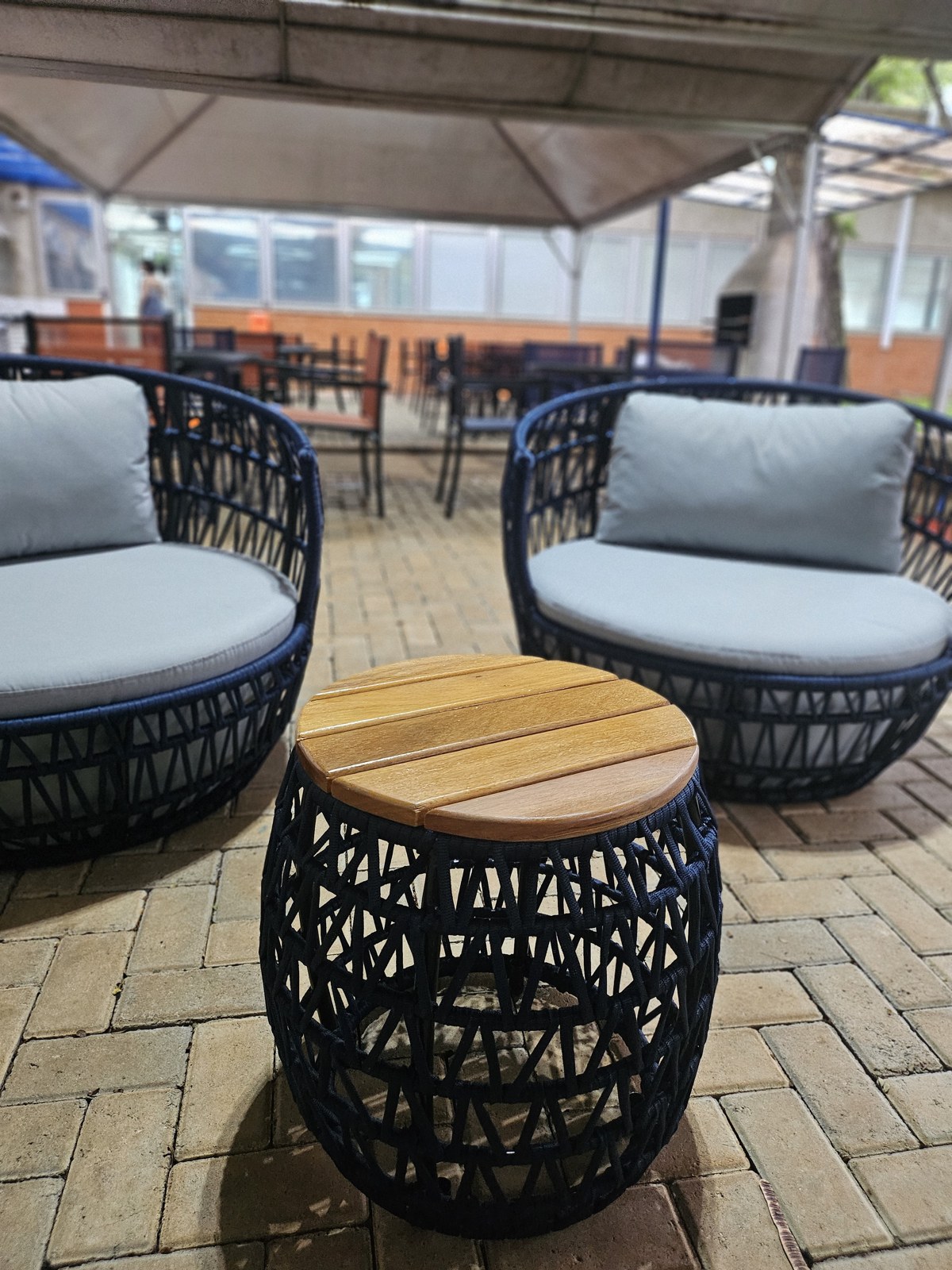 Sillas de cuerda de Mavie con mesa de apoyo en un salón exterior corporativo