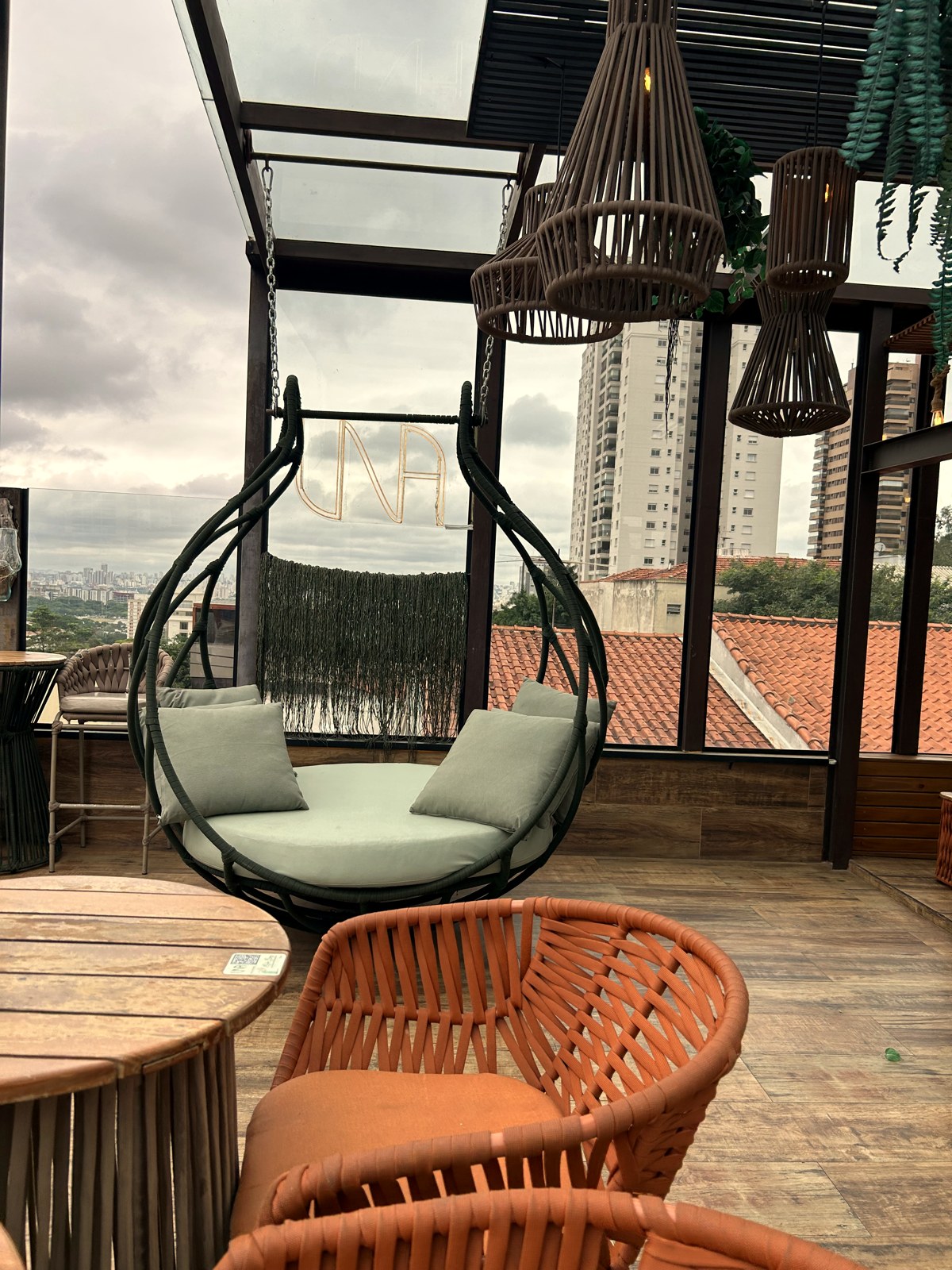 Silla colgante y silla de cuerda naranja de Mavie en el tejado del Restaurante de Una