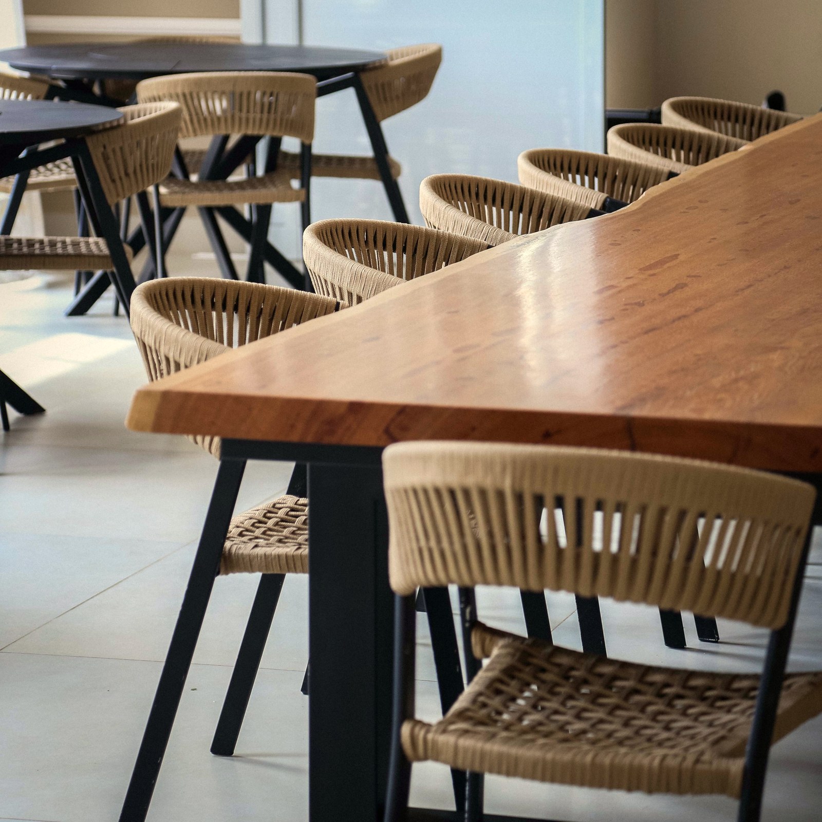 Salón del Condominio Vista Araras con mesa grande de madera y sillas de cuerda de la marca Mavie