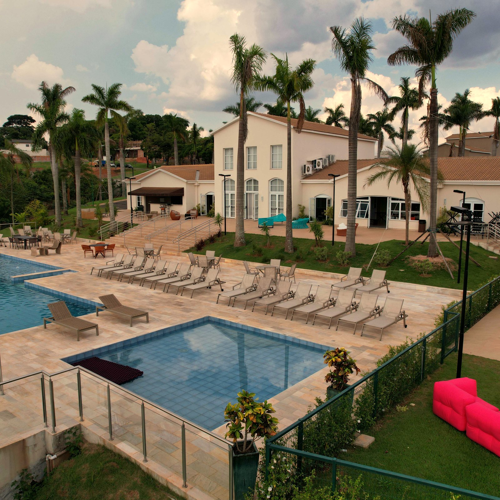 Vista aérea de la zona de ocio del condominio Vista Araras, con piscinas y muebles de Mavie