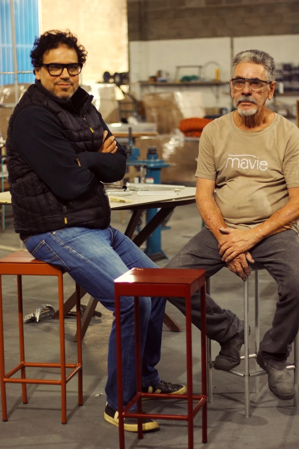 Estevão Toledo con el serrador Sr. João en la fábrica de Mavie, entre piezas de aluminio