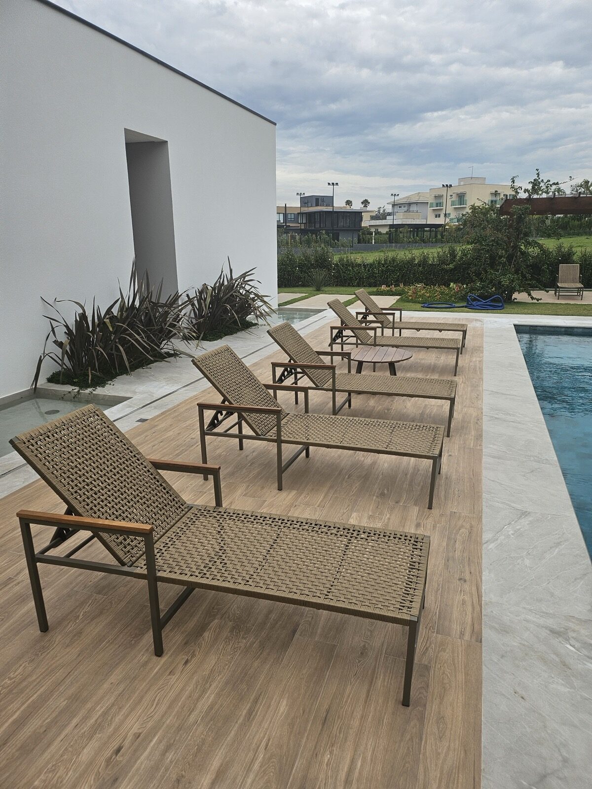 Vista aérea de una piscina residencial con un daybed de Mavie